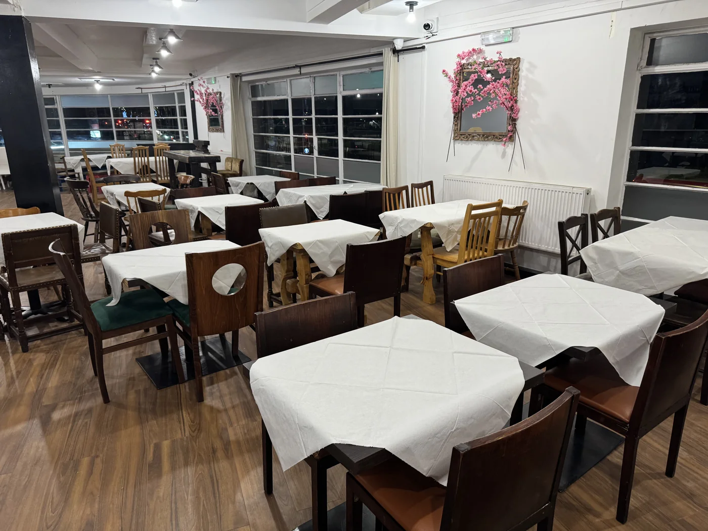 White-covered tables and wooden chairs inside Last Tango.