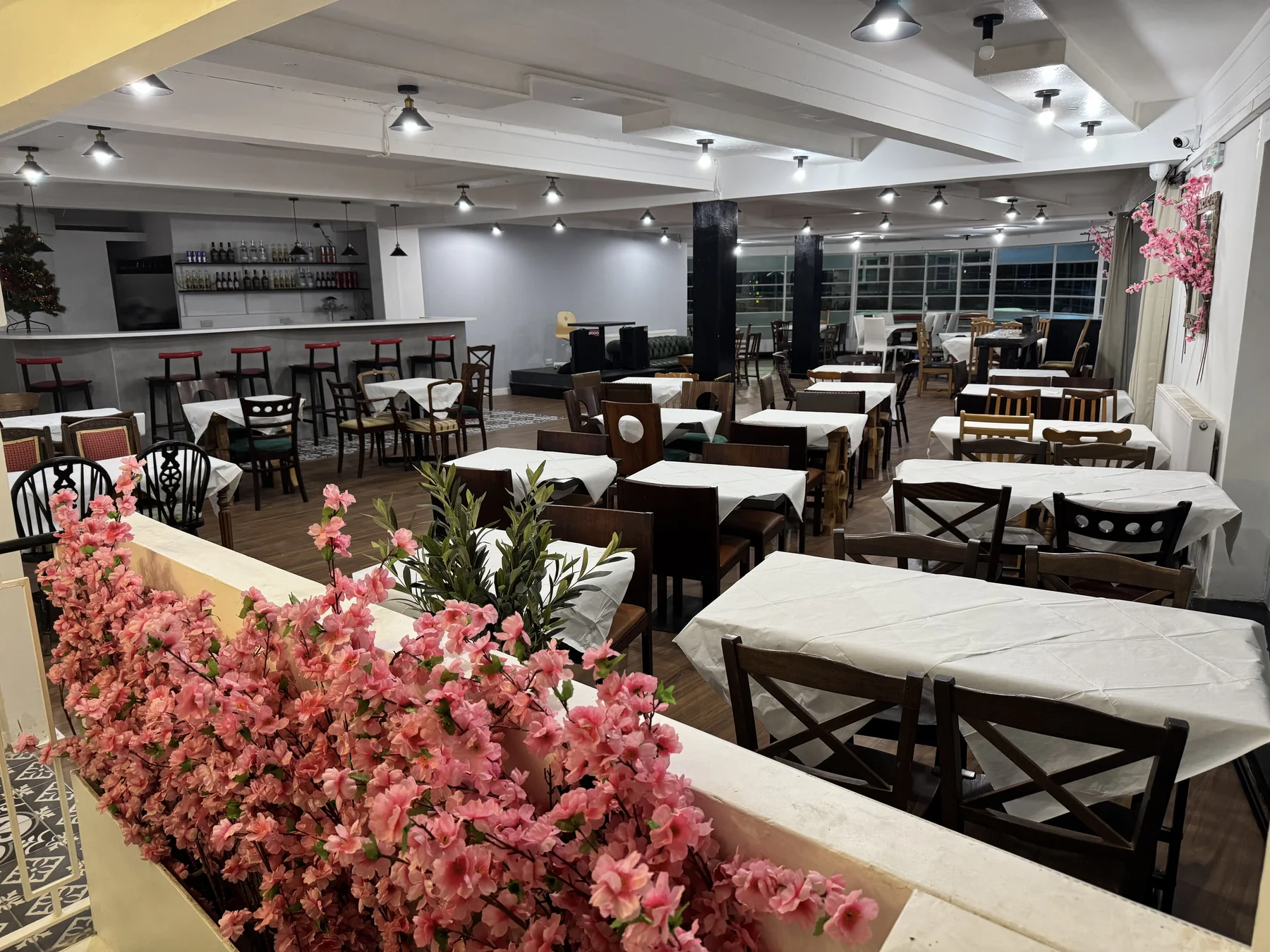 A full view of Last Tango with blossom decorations, white-covered tables and the bar.