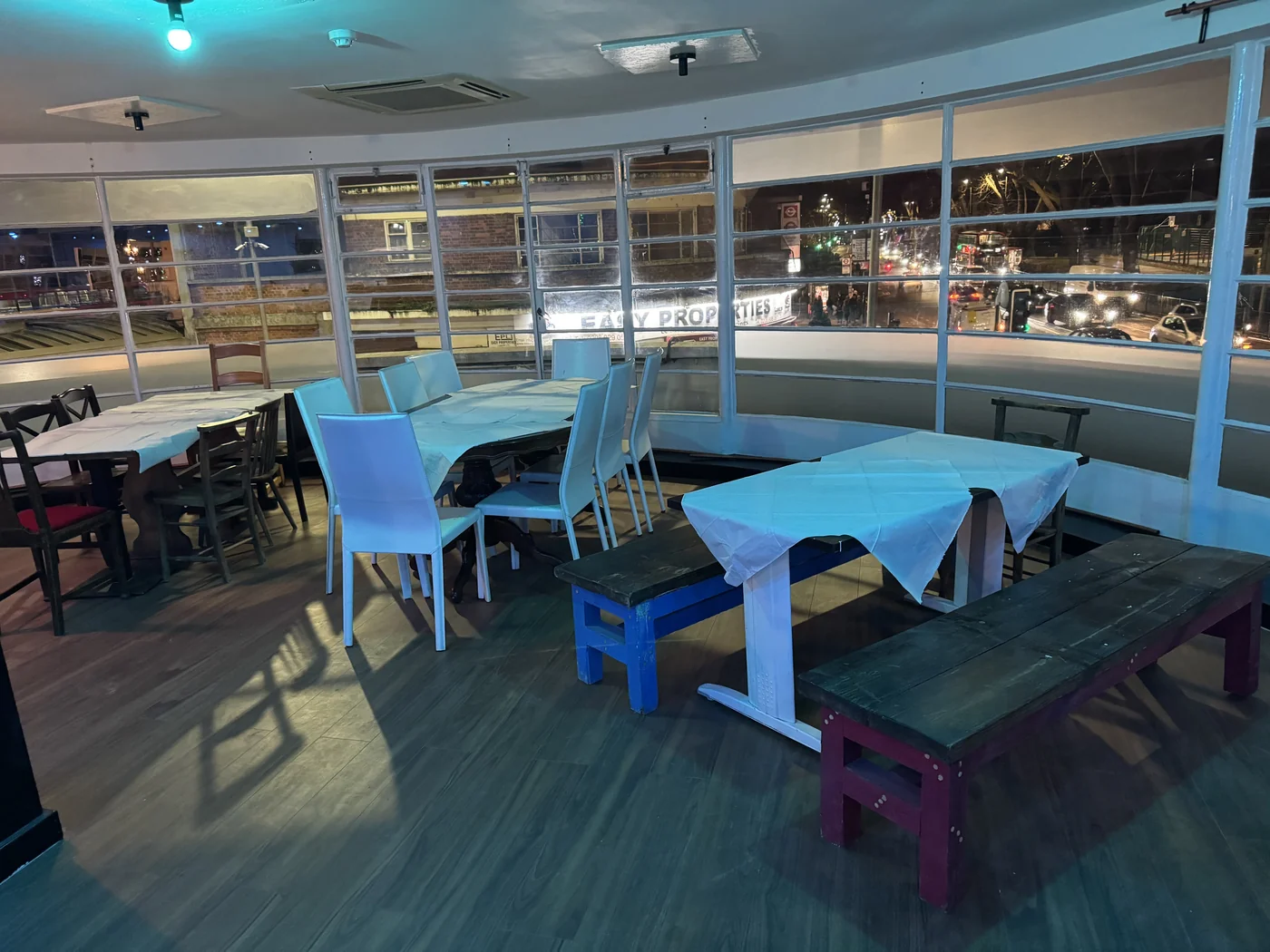 Tables and chairs along the venue's curved windows.